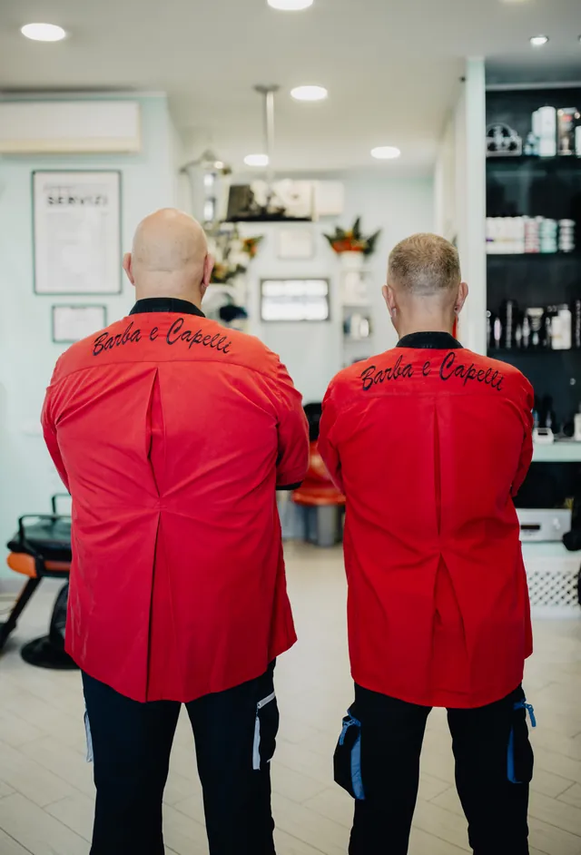 Tito e Fabrizio di spalle, con «Barba e Capelli» scritto sulle giacche