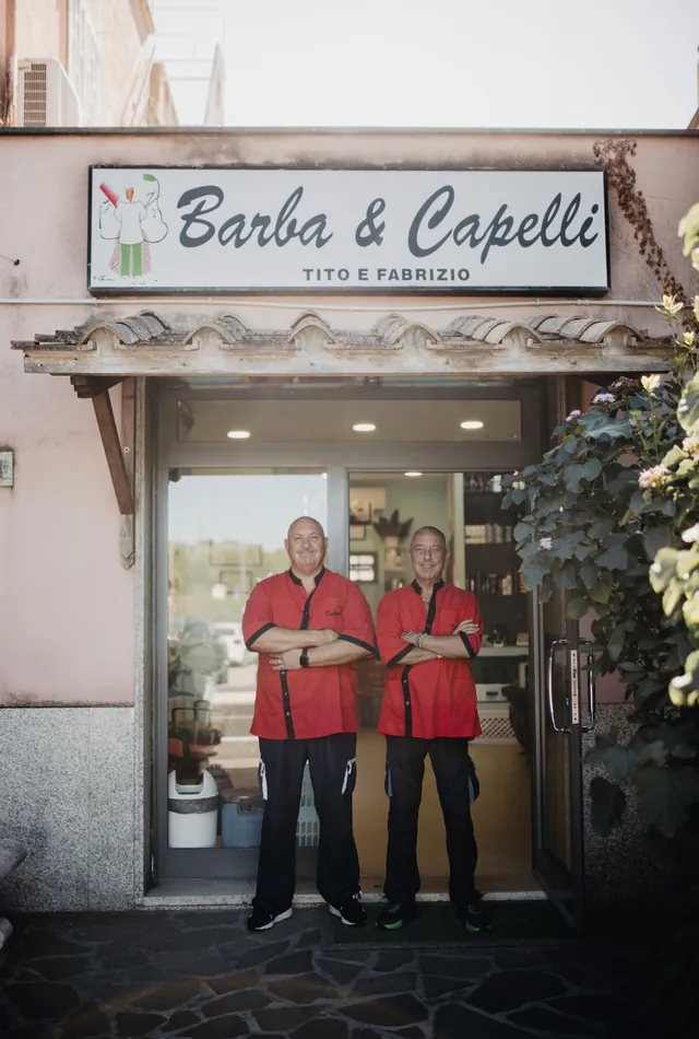 L'ingresso di Barba & Capelli, con Tito e Fabrizio sulla porta